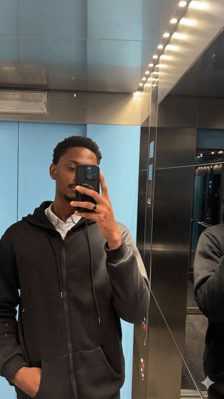 A casual mirror selfie in a black zip-up hoodie inside an elevator.